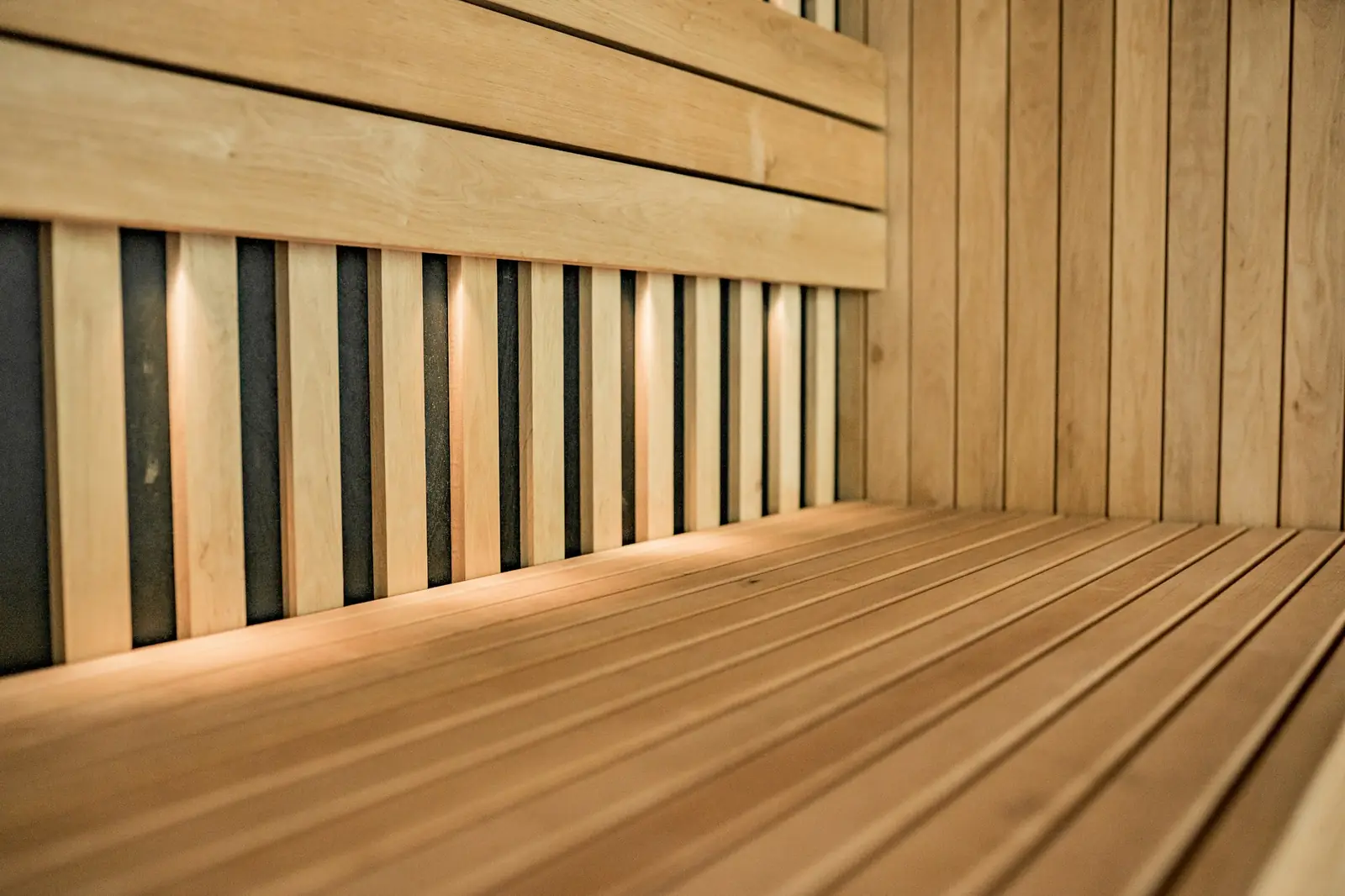 Close view of a slatted wooden sauna bench and wall