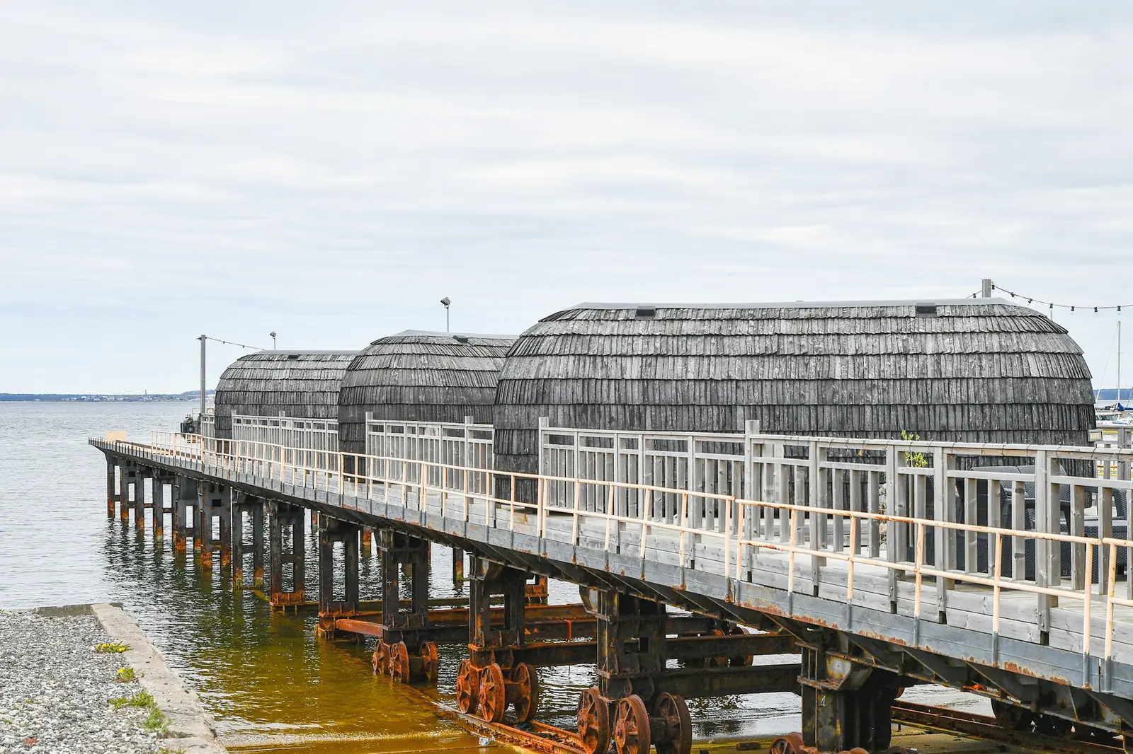 Wooden saunas with curved roofs on a pier over a lake