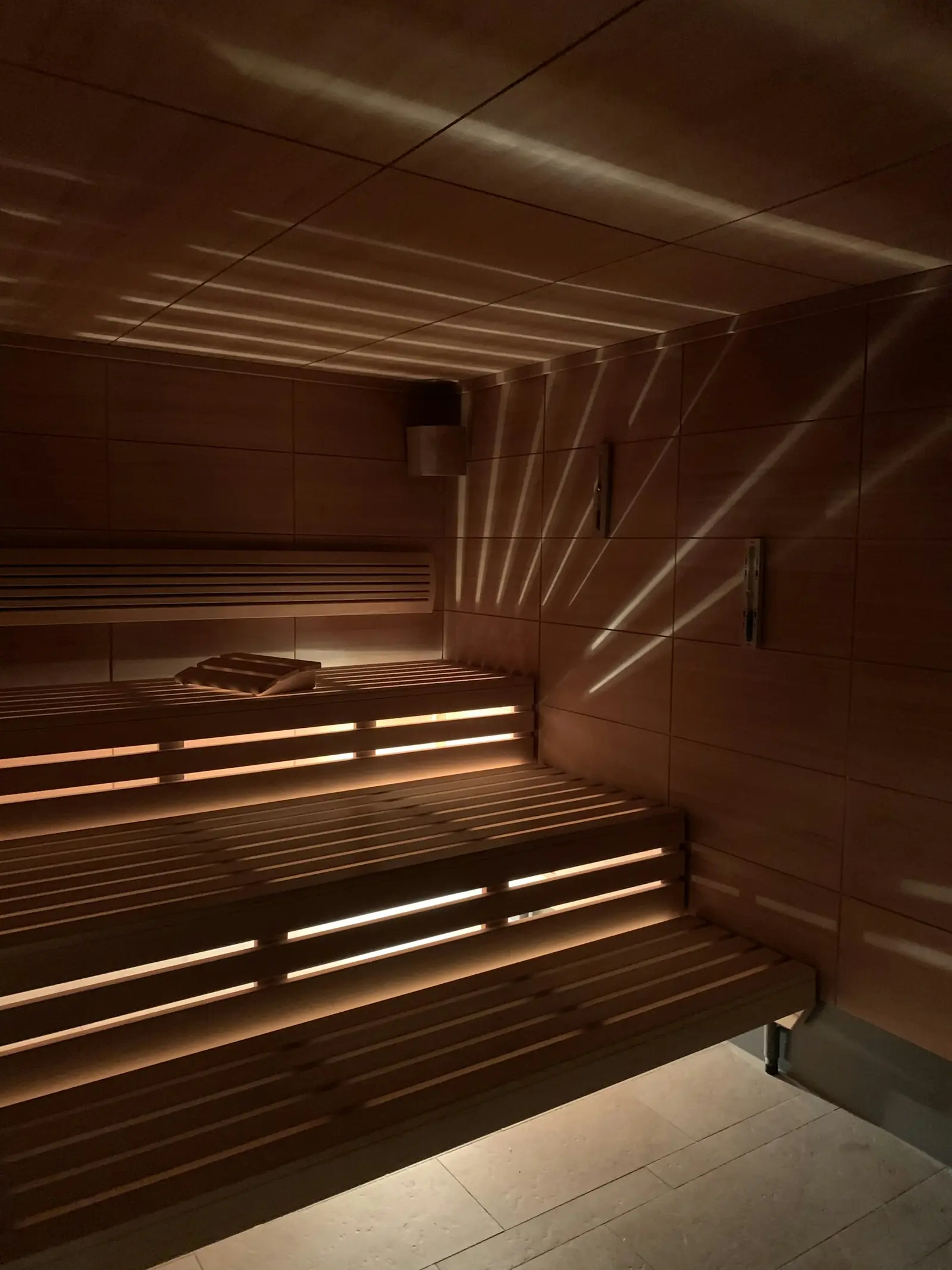 Two levels of wooden sauna benches lit from underneath